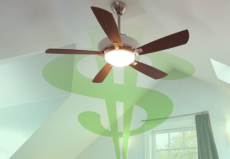 A modern ceiling fan with five wooden blades and a central circular light fixture, mounted on a white, angled ceiling.