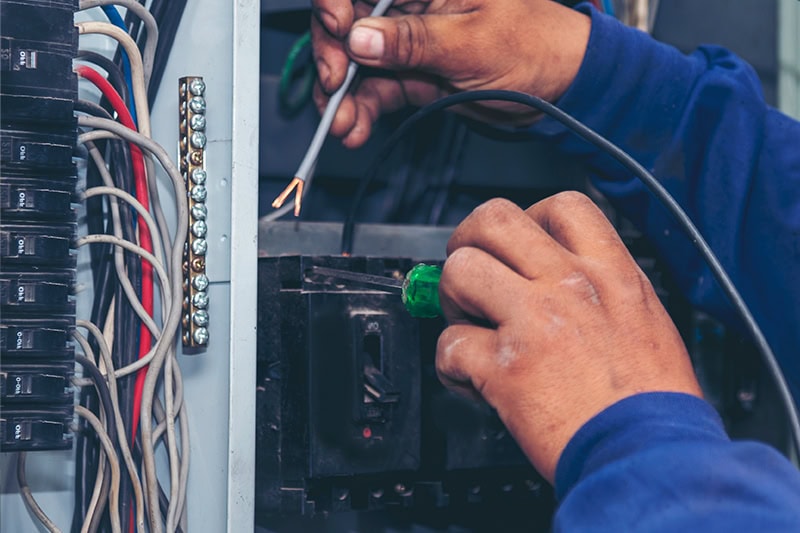 Technician working on electrical panel.