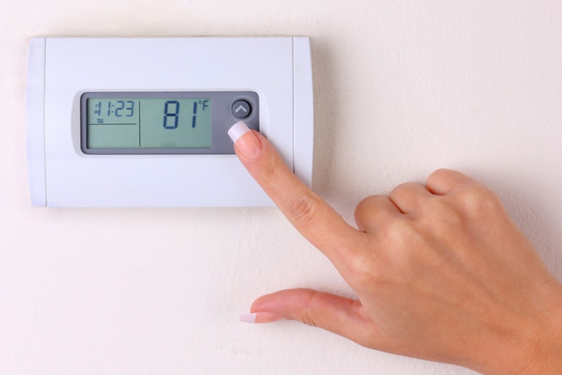 hand touching a thermostat